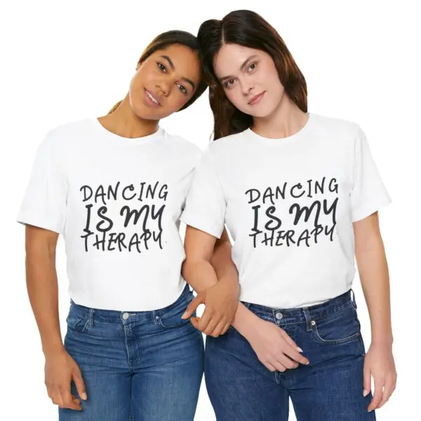 Two women wearing "Dancing Is My Therapy" shirts.