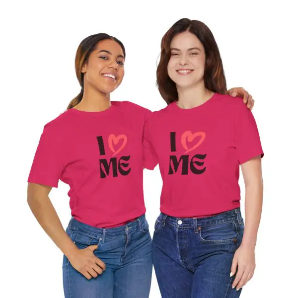 Two women wearing matching pink "I Love Me" shirts.