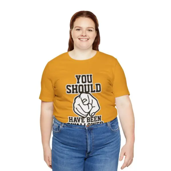 Person wearing humorous yellow shirt, smiling.