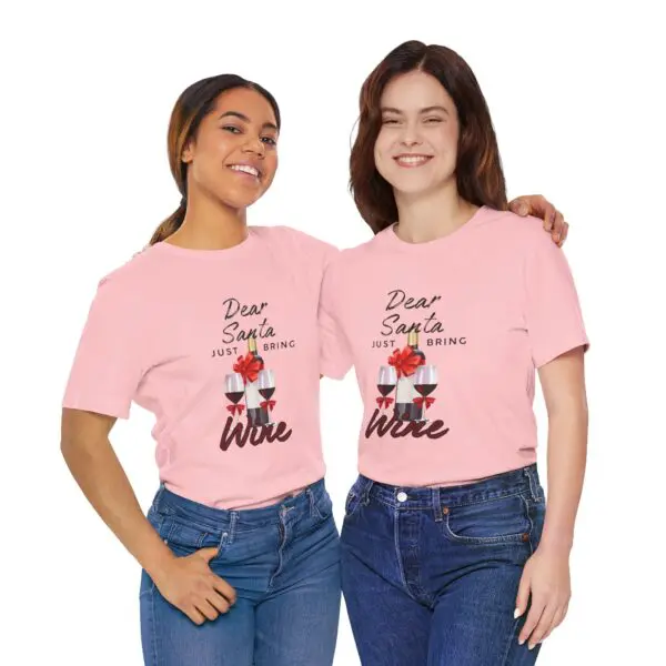 Two women wearing matching pink wine shirts.