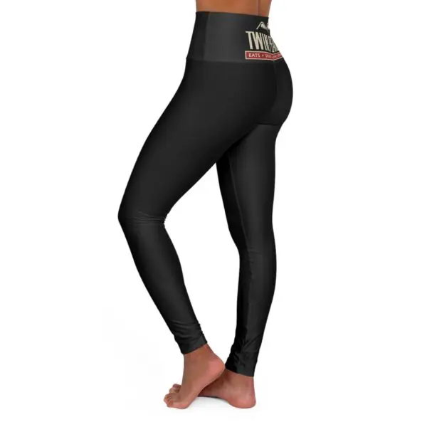 Black leggings with waistband logo, side view.