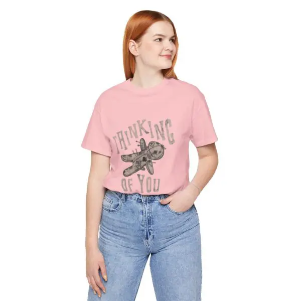 Woman wearing pink "Thinking of You" shirt.
