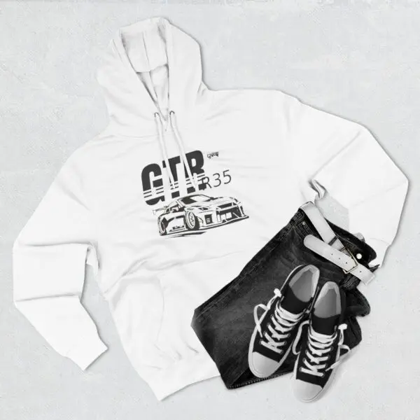 White hoodie, jeans, sneakers, and belt ensemble.