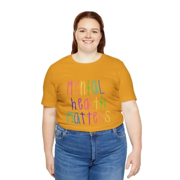 Smiling person wearing "Mental Health Matters" shirt.