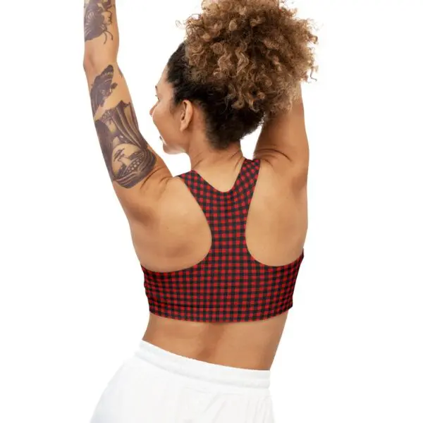 Woman in checkered sports top, stretching arms.