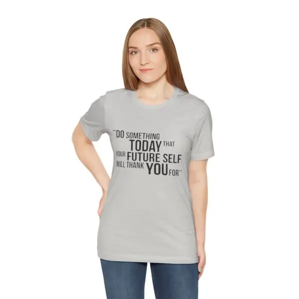 Woman wearing motivational t-shirt, standing confidently.