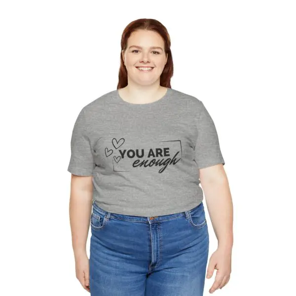 Smiling person wearing "You Are Enough" shirt.