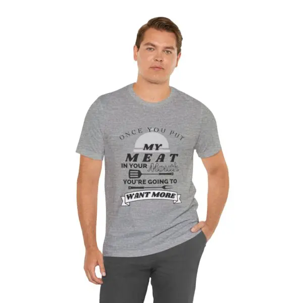 Man wearing humorous grey t-shirt, hand in pocket.