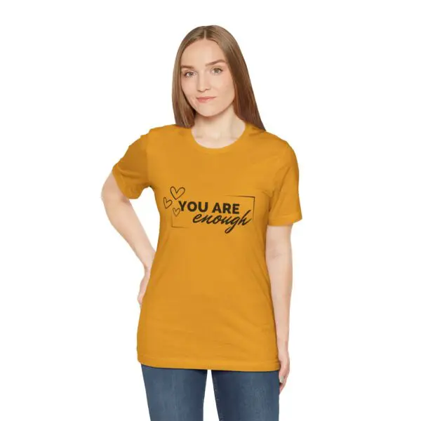 Woman wearing yellow "You Are Enough" shirt.