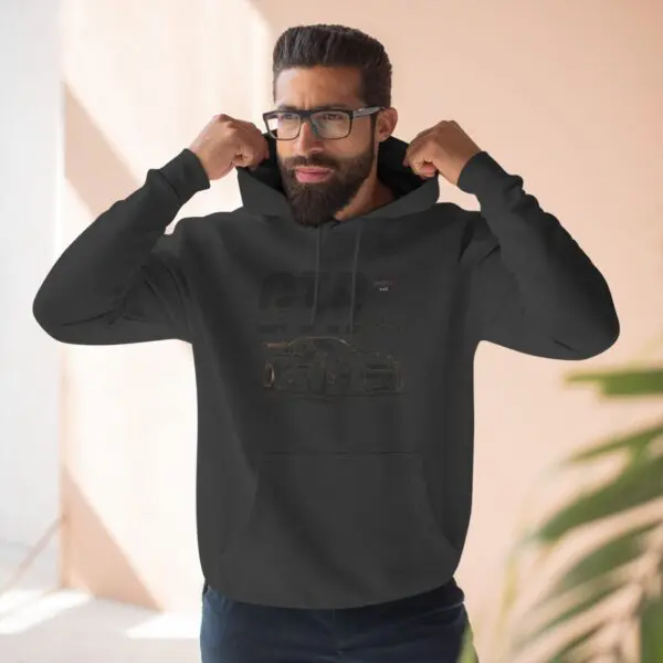 Man wearing a black hoodie indoors.
