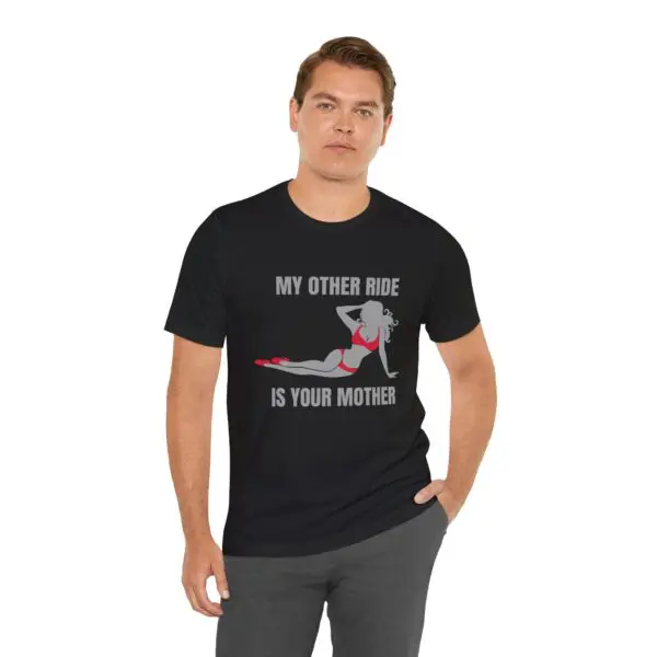 Man wearing humorous graphic t-shirt, black background.