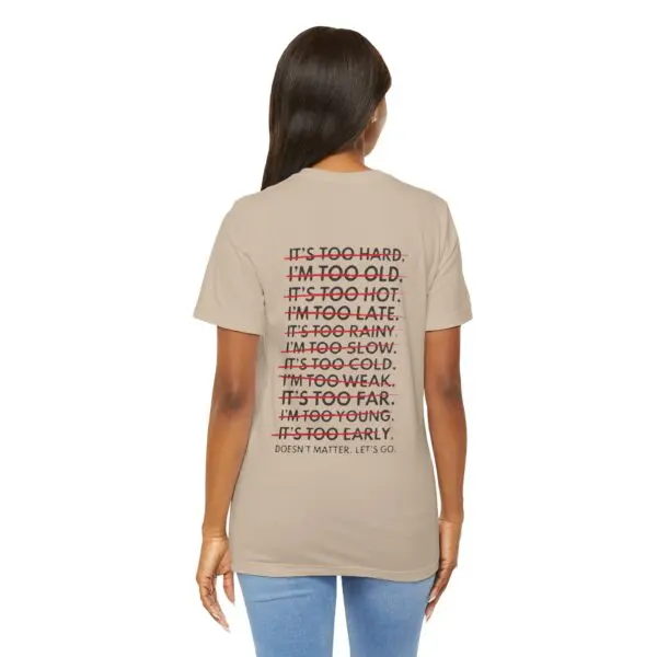 Woman wearing motivational text t-shirt, jeans.