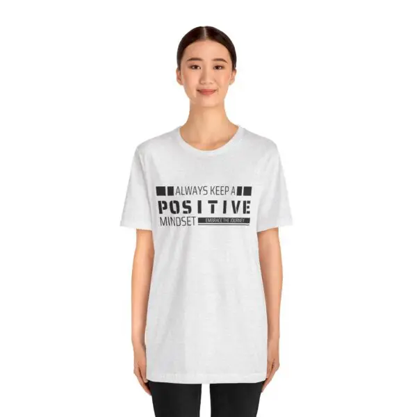 Woman wearing positive mindset t-shirt, smiling.