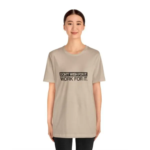 Person wearing motivational quote t-shirt, smiling.
