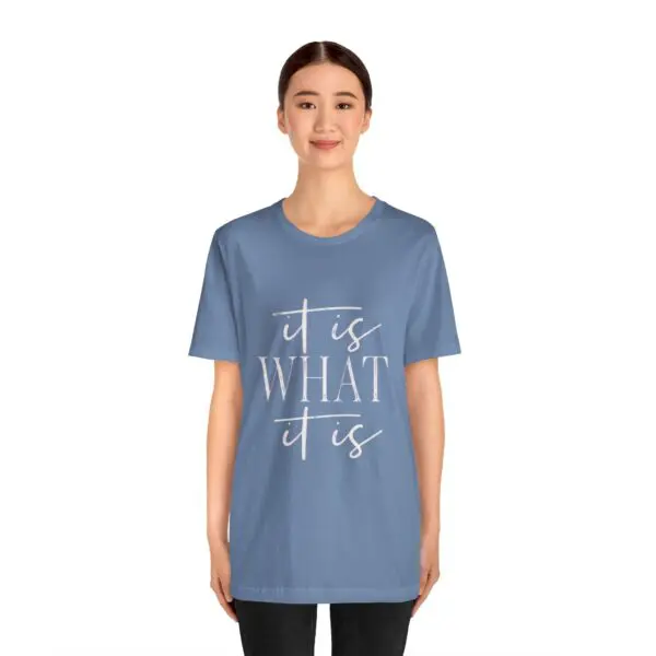 Person wearing blue "It Is What It Is" shirt.