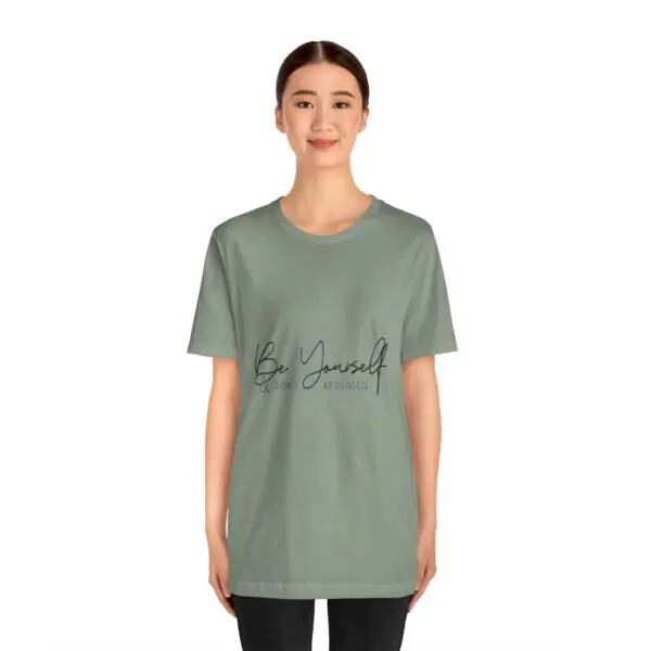 Smiling person wearing "Be Yourself" t-shirt.