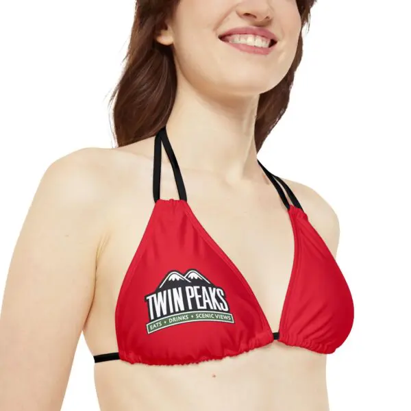 Woman wearing red bikini with logo.