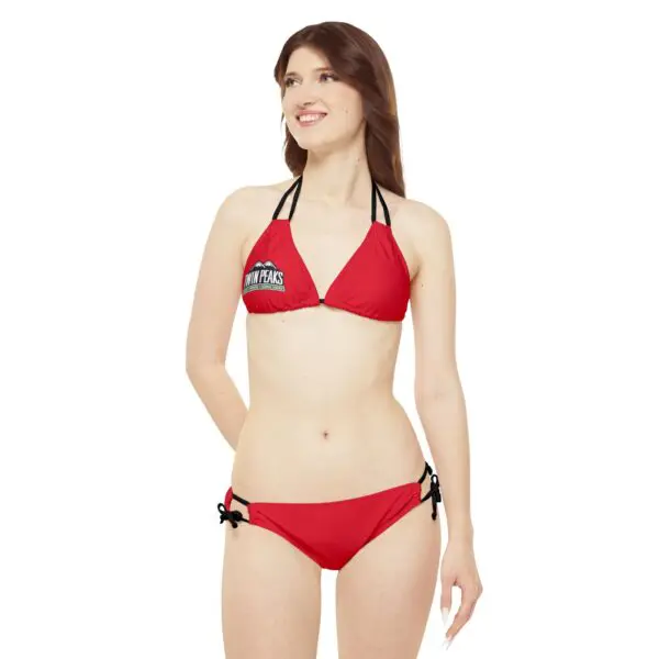 Woman in red bikini, smiling, looking away.