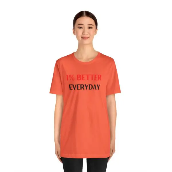 Person wearing orange motivational t-shirt, smiling.