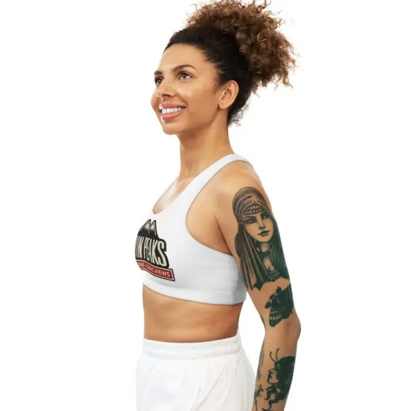 Smiling woman with curly hair and tattoos.