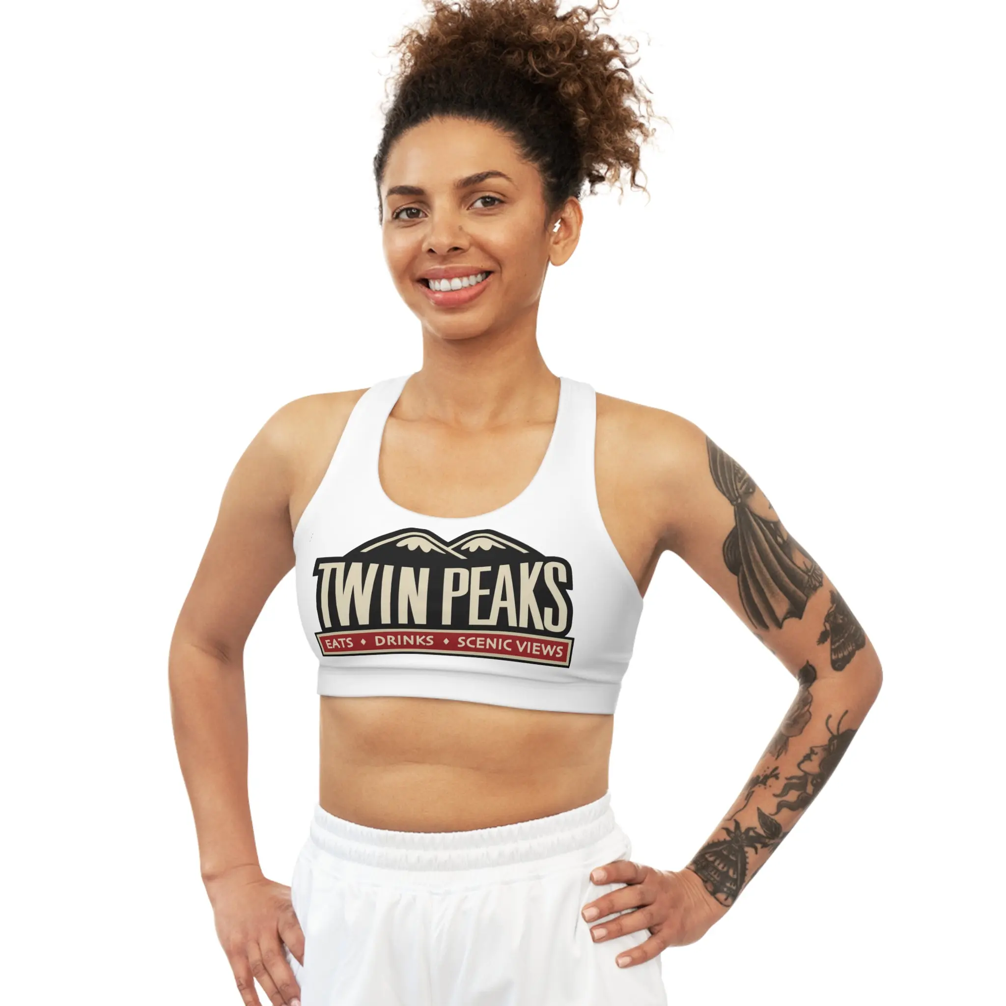 Smiling woman in Twin Peaks branded outfit.