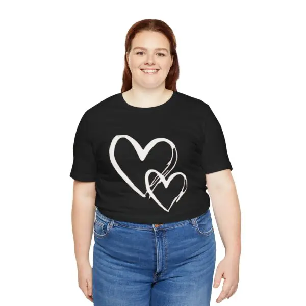 Smiling woman in heart-print black shirt.