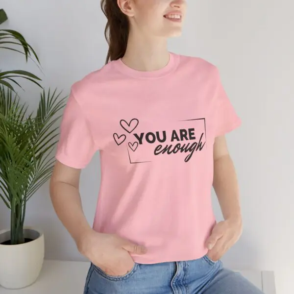 Woman in pink "You Are Enough" shirt.