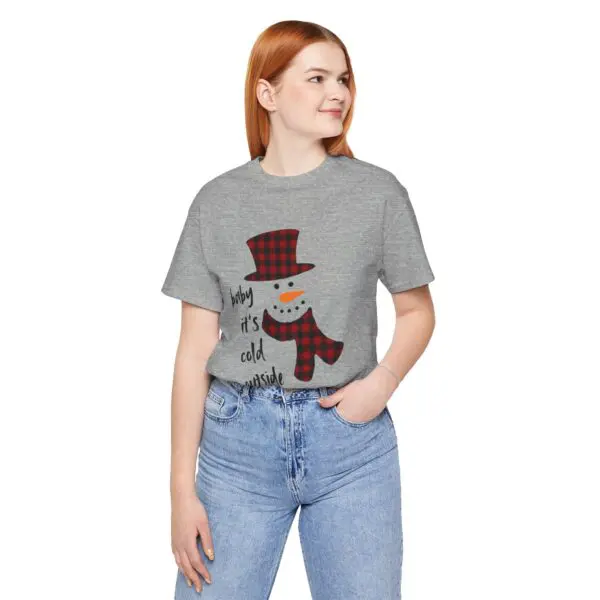 Woman wearing snowman graphic t-shirt, smiling.