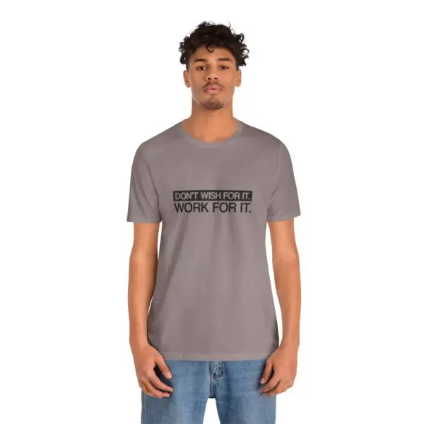 Man wearing motivational t-shirt, gray background.