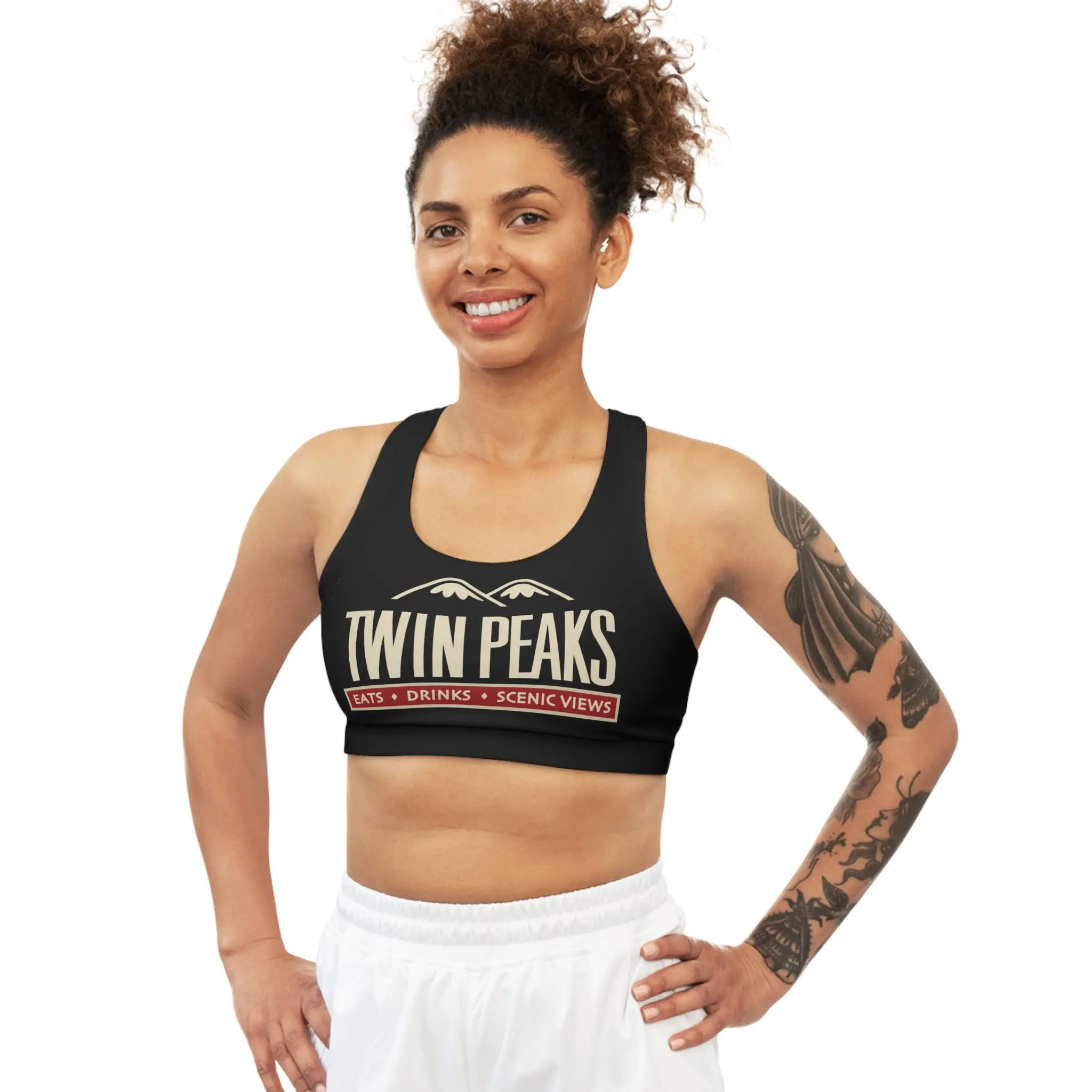 Smiling woman in sportswear with tattoos.