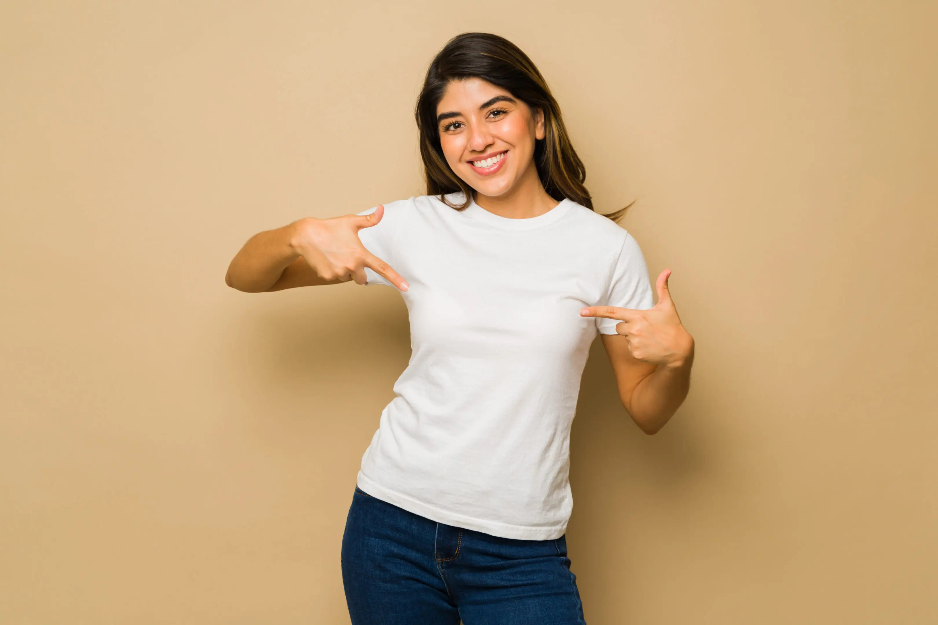 Excited woman showing her white mockup t-shirt Smiling person pointing at white shirt.