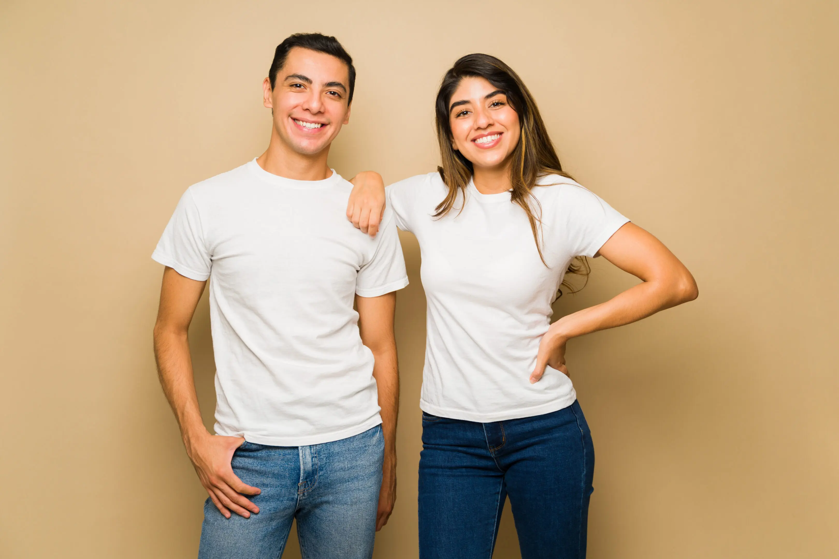 Attractive couple with white mock-up t-shirts Smiling couple wearing white shirts and jeans.